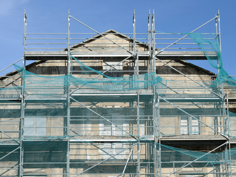 Older residential building covered in scaffolding